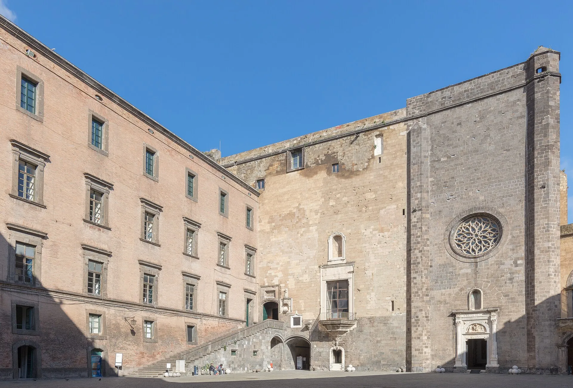 Il cortile interno di Castel Nuovo con la scala monumentale e il rosone della Cappella Palatina
